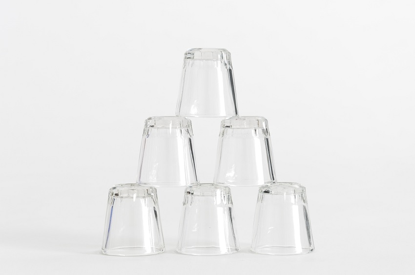 Six shot glasses without custom engravings from Paykoc Imports stacked in pyramid formation